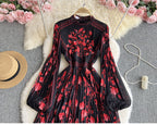 Black and red floral dress displayed with decorative elements on a gray background